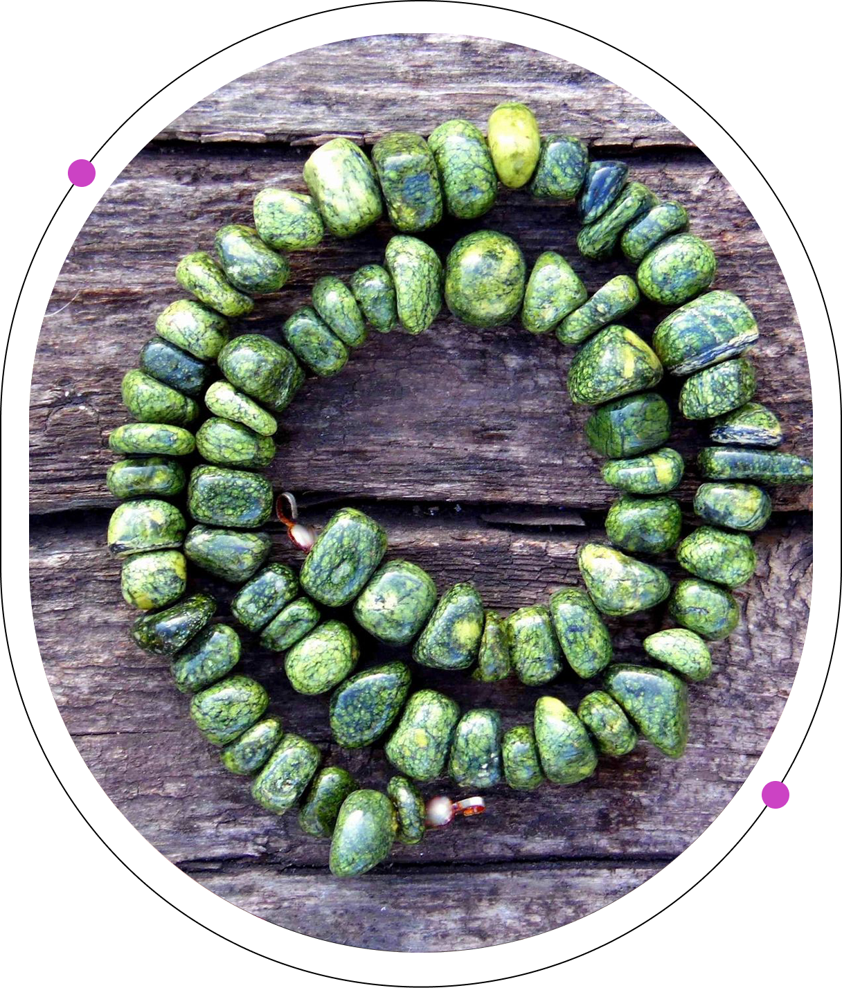 A green bead necklace sitting on top of a wooden table.