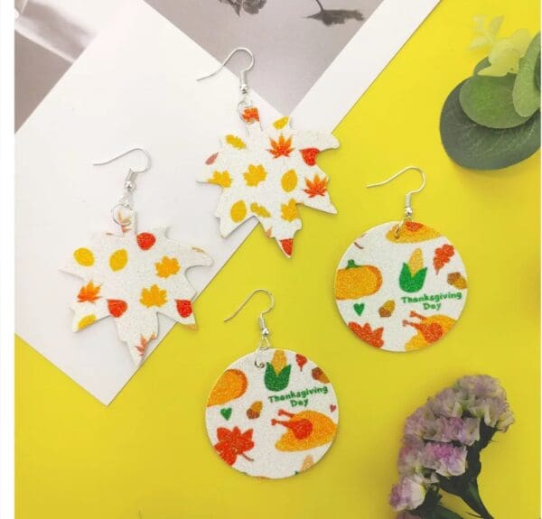 A yellow table with four different types of earrings.