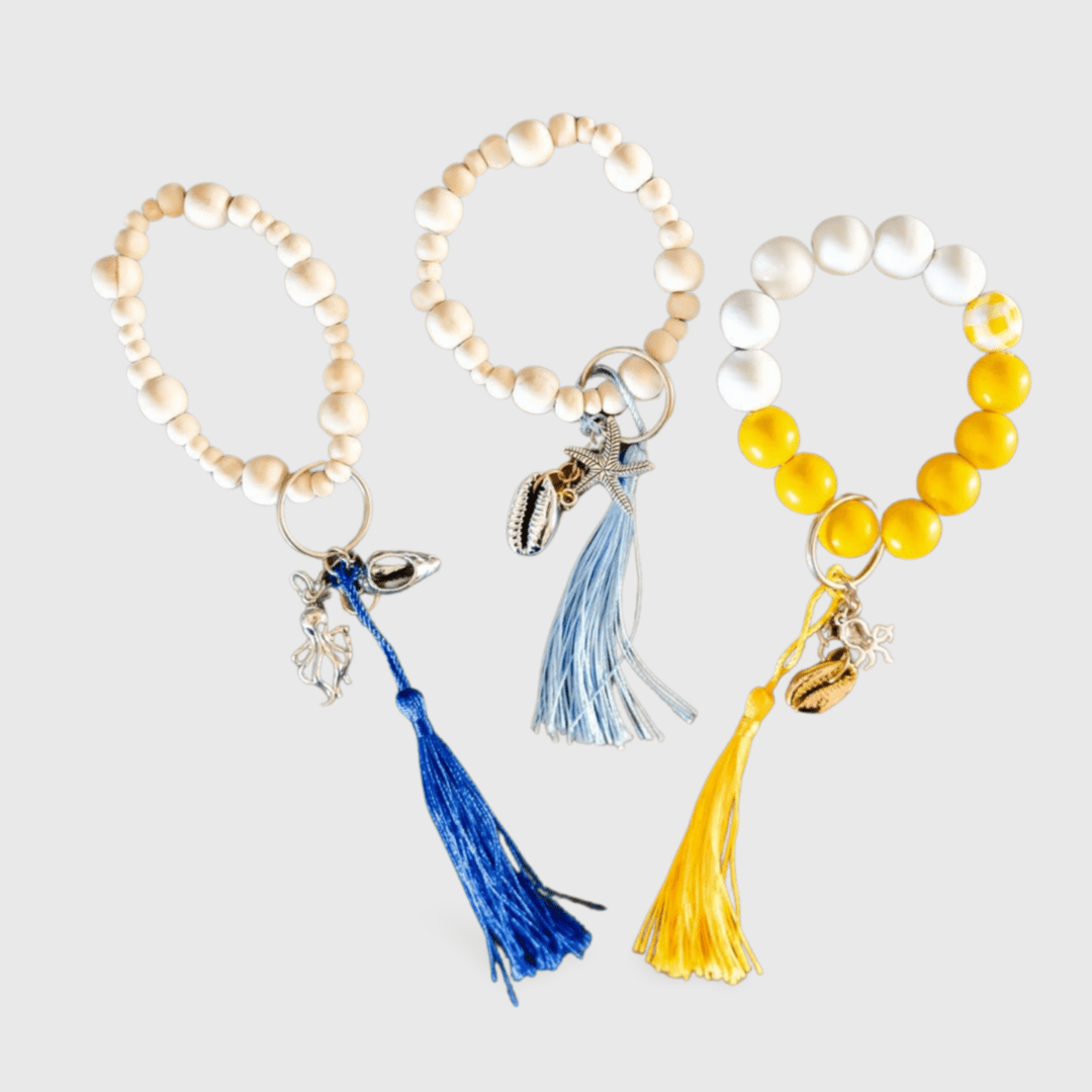 Three bracelets with tassels and a shell charm.