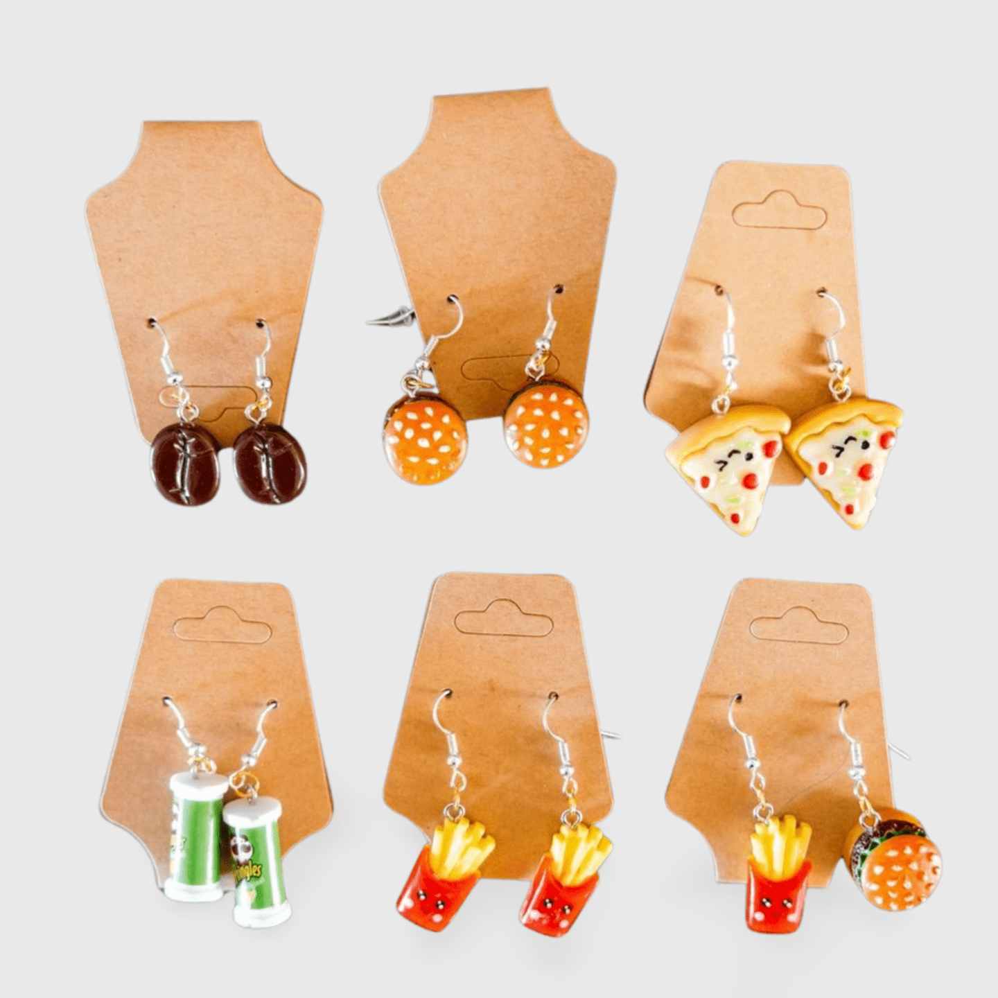 Six different earrings hanging on a brown cardboard.