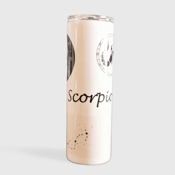 A white candle with the word scorpio written on it.