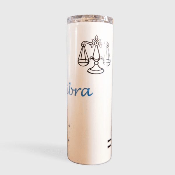 A tall white candle with the word libra written on it.