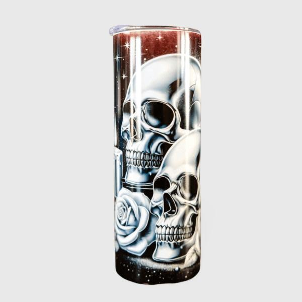 A tall glass with skulls and roses on it.