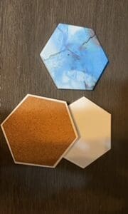 A table with three different colored coasters on it.