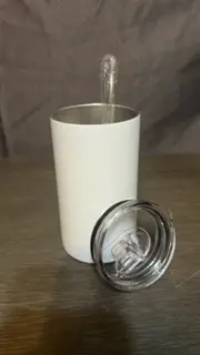 A white cup with a clear lid on top of a table.