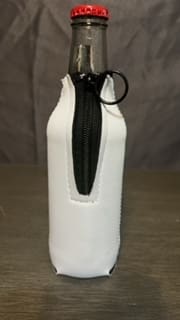 A white bottle with a black zipper on top of it.