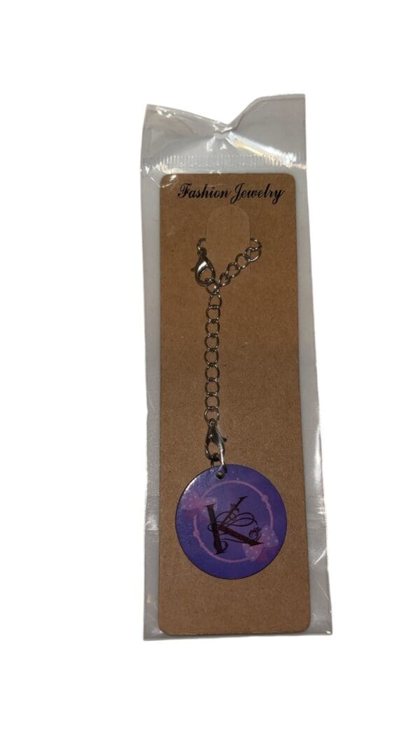 A purple keychain with the letter k on it.