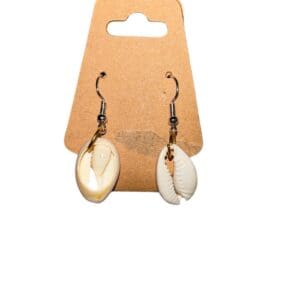 A pair of earrings hanging on a brown card.