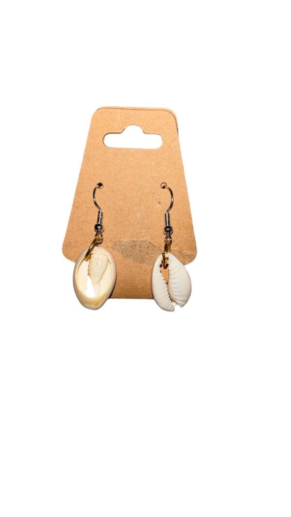 A pair of earrings hanging on a brown card.